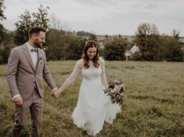 Glücklicher Bräutigam lächelt seine Braut an und Hochzeitsfotografin Martina Feicht fotografiert sie