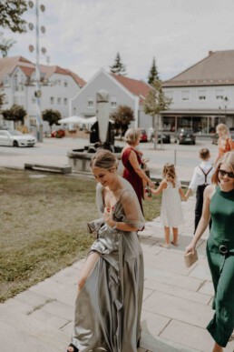 Mit einem eleganten Outfit machen sich die Hochzeitsgäste auf zur Kirche und warten auf das Brautpaar im BMW