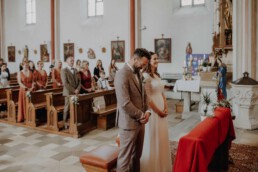 Brautpaar steht am Altar in der Kirche und die Hochzeitszeremonie beginnt gleich in der Nähe von Passau