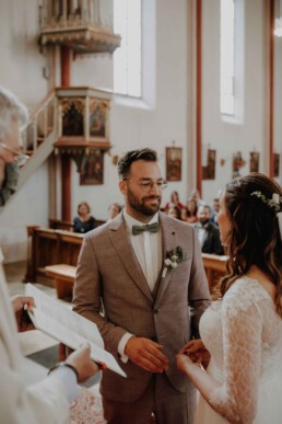 Braut und Bräutigam stehen sich gegenüber bei der kirchlichen Trauung fotografiert von Martina Feicht , Passau