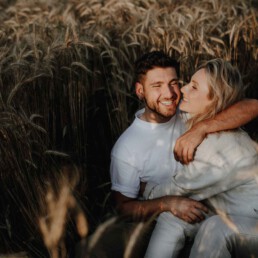 Paarshooting im Feld im Sommer im Sonnenuntergang fotografiert von Martina Feicht Fotografie