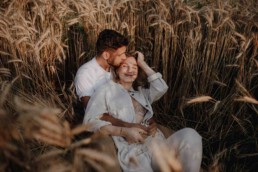 Paarshooting im Feld im Sommer im Sonnenuntergang fotografiert von Martina Feicht Fotografie