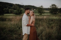 Paarshooting im Feld im Sommer im Sonnenuntergang fotografiert von Martina Feicht Fotografie