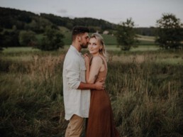 Paarshooting im Feld im Sommer im Sonnenuntergang fotografiert von Martina Feicht Fotografie