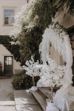 Eingang zur Trauung mit Kirschblütenbäumen am Hochzeitstag im Schloss Altenhof